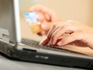 Hands holding credit card and laptop. Shallow DOF